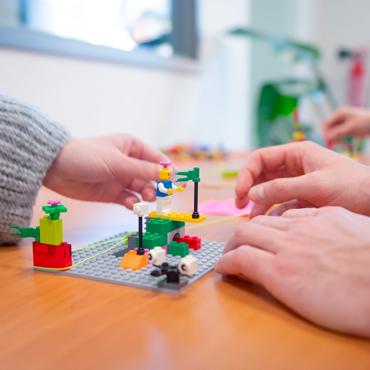 Mani che montano modellino con mattoncini Lego da una sessione di workshop Lego Serious Play