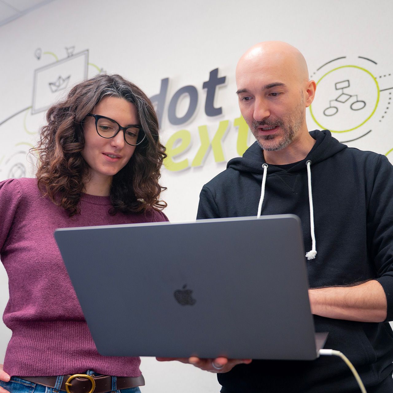 Due persone del team di Dot Next in ufficio si confrontano davanti al pc